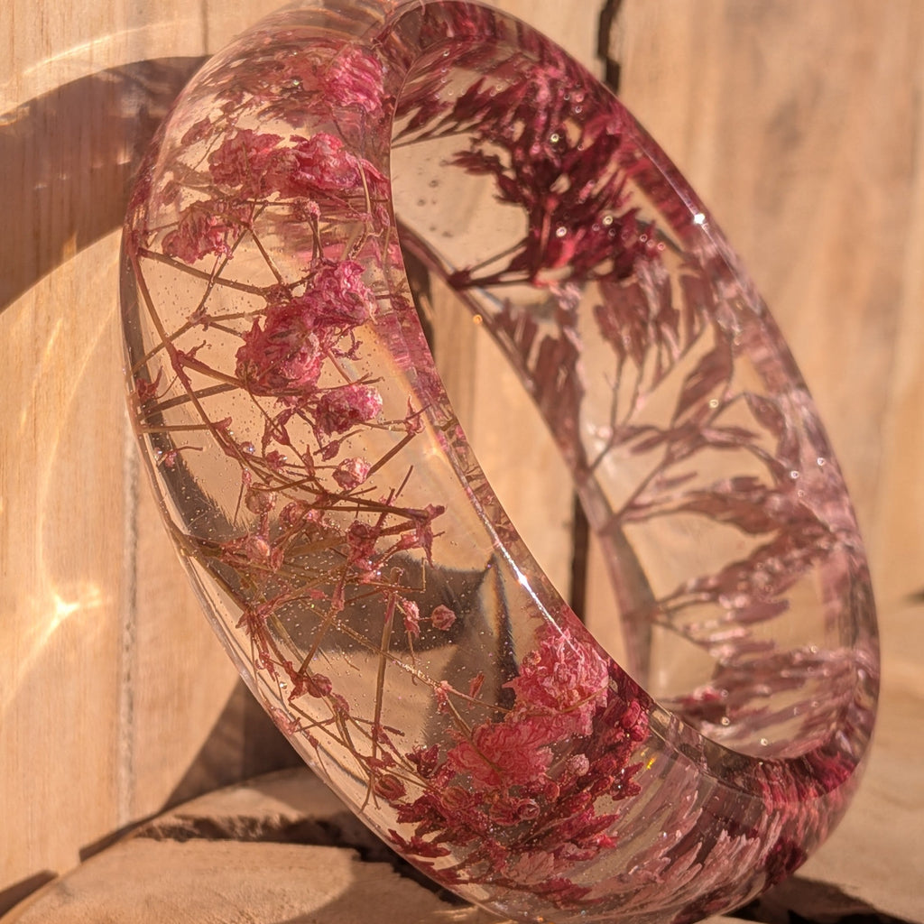 Resin botanical bracelet with dried pink wild flowers – leaning view showing inner diameter – EL-Creations