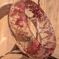 Resin botanical bracelet with dried pink wild flowers – leaning view showing inner diameter – EL-Creations