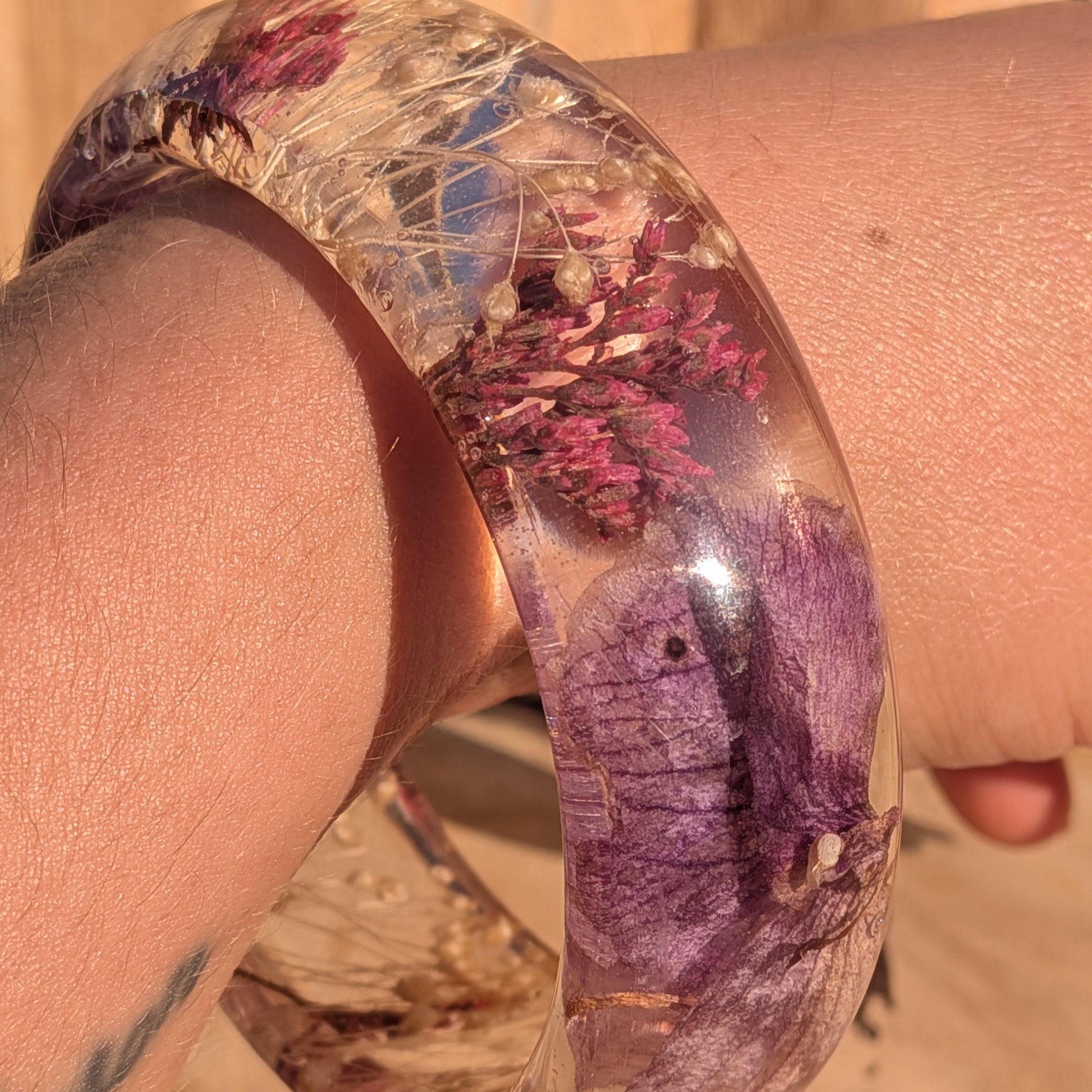 Clear resin bangle with dried orchid petals and wild flowers – wrist shot showing inner diameter – EL-Creations