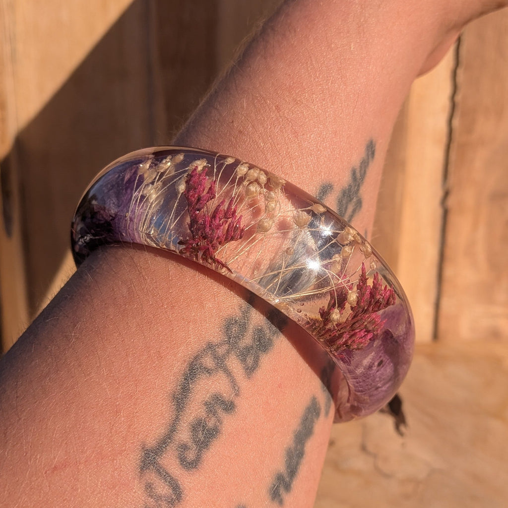 Botanical resin bangle with purple orchid and red heather – full wrist view in natural light – EL-Creations