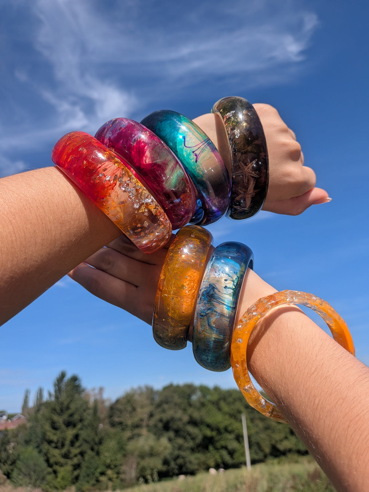 Multiple handmade resin bangles stacked on wrists showing EL-Creations colour range – EL-Creations