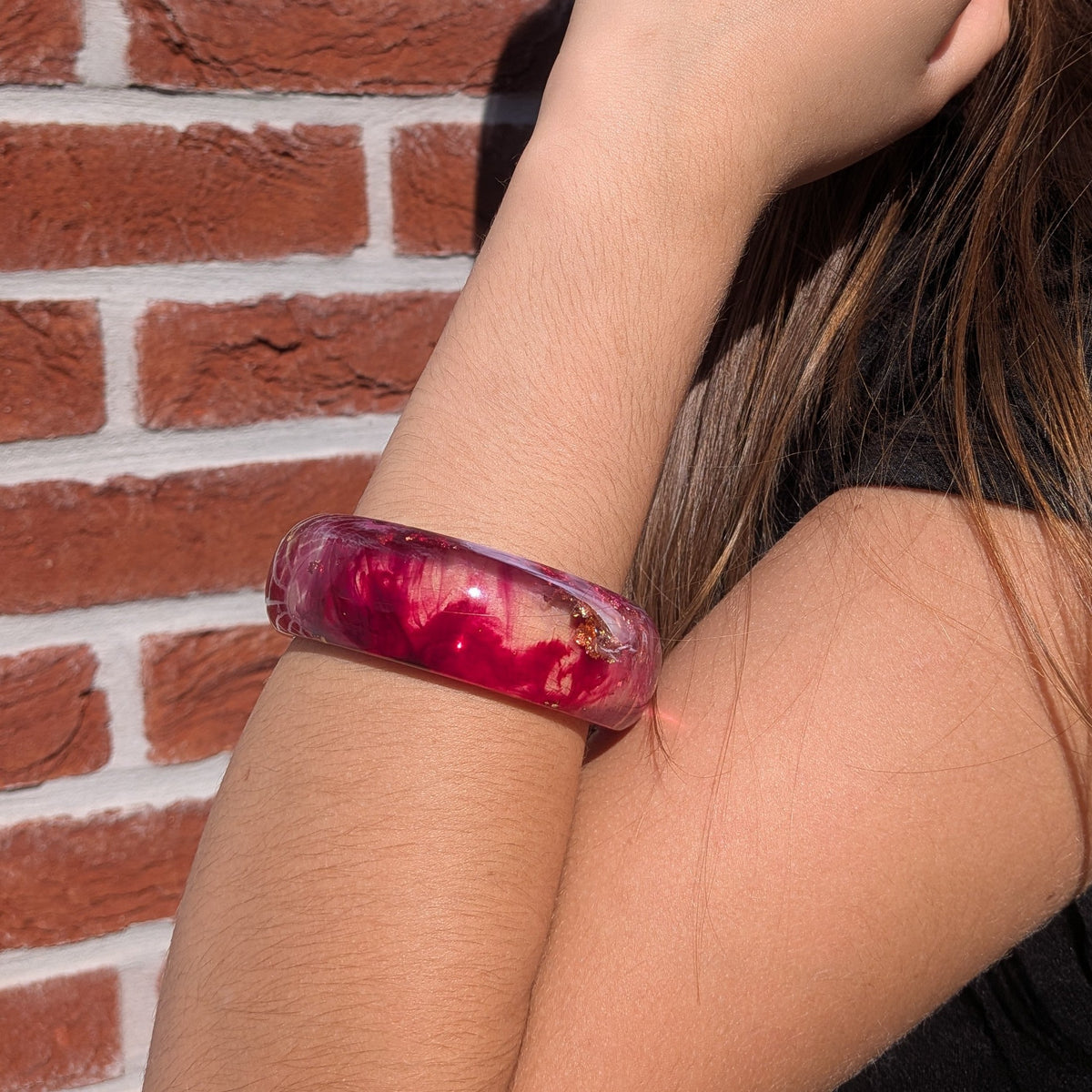 Wild berry resin bangle on natural wood surface outdoors showing burgundy pink tones in sunlight – EL-Creations