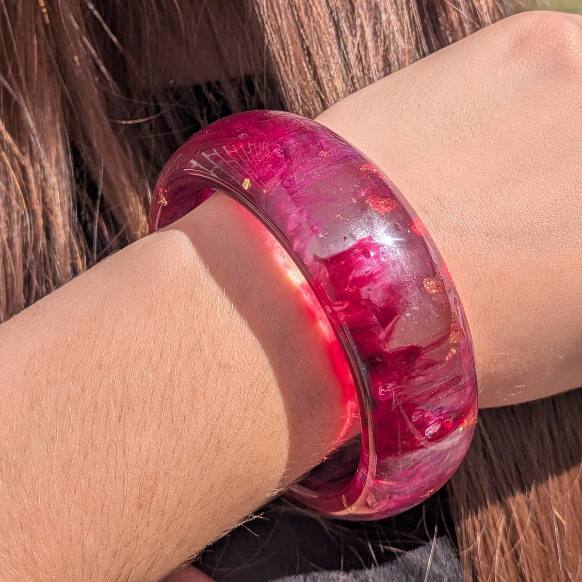Handmade wide burgundy resin bangle with rose gold leaf details on rustic wood surface – EL-Creations