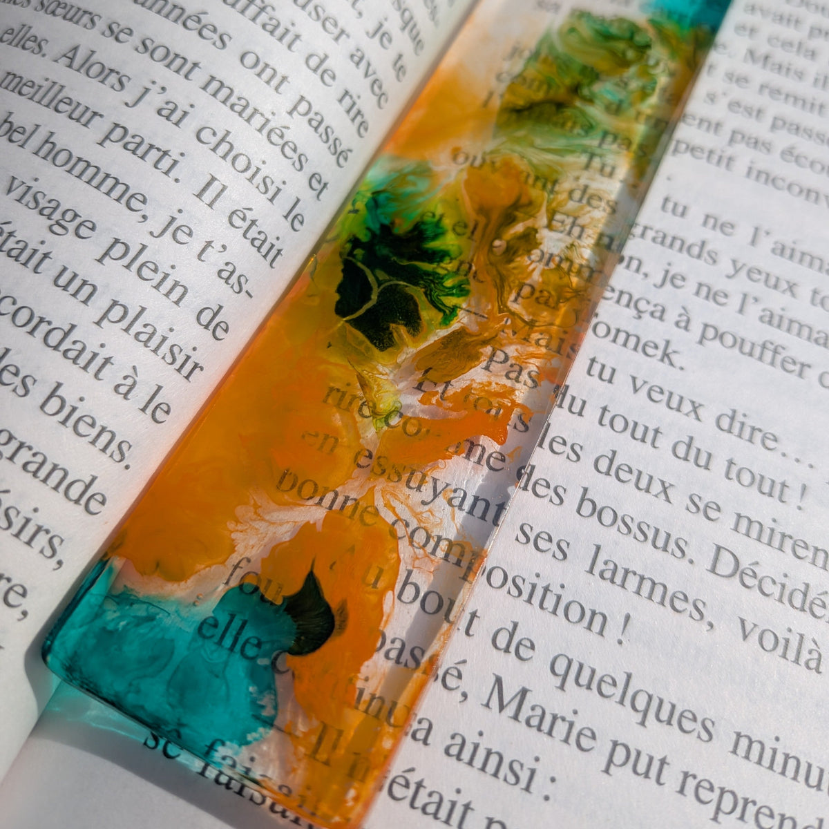 Handmade resin bookmark with orange teal green fluid art swirl on open book – EL-Creations