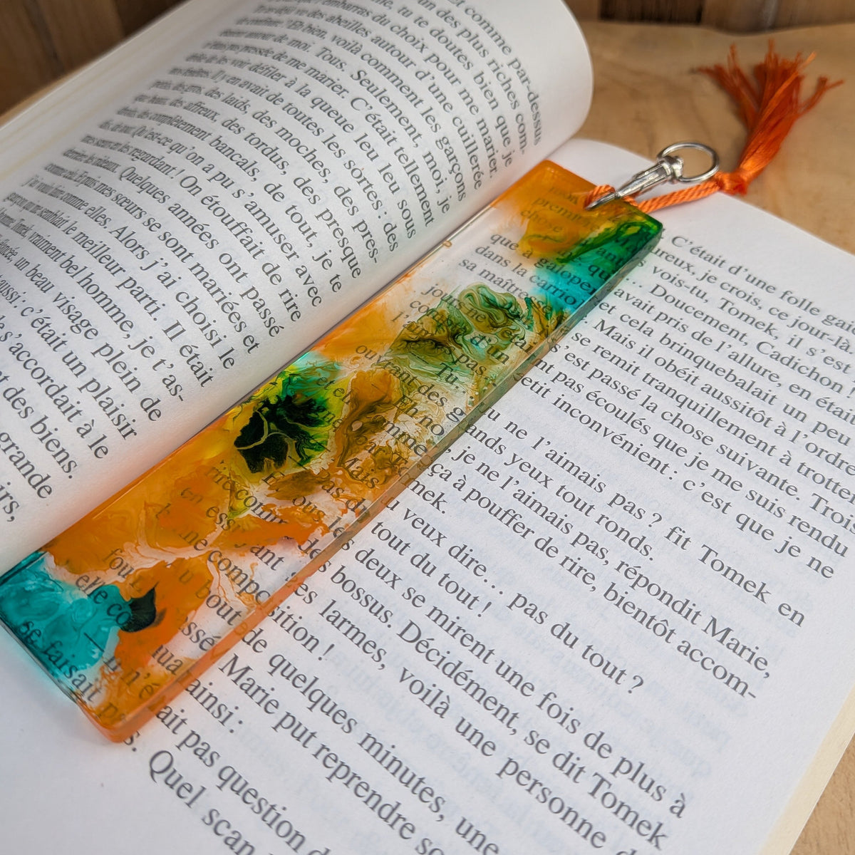 Resin bookmark keychain lying flat on open book pages – EL-Creations