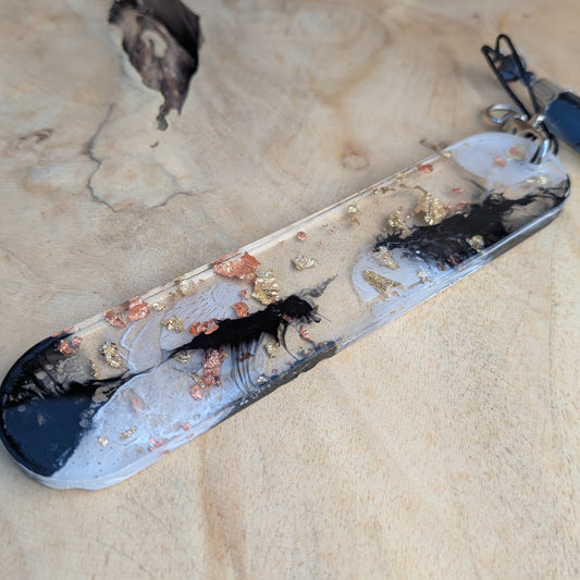 Handmade resin bookmark with copper gold leaf and black ink swirl on wooden surface – EL-Creations