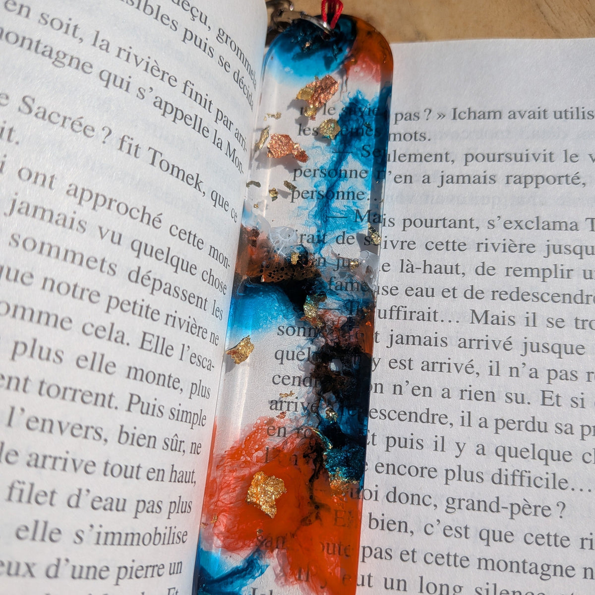 Full length view of electric blue and orange epoxy resin bookmark on open book – EL-Creations