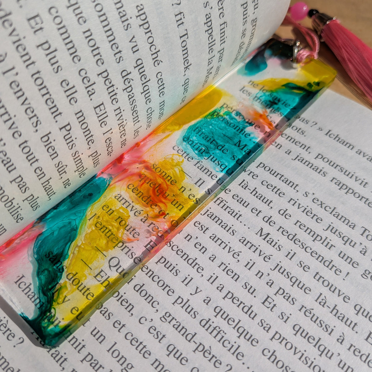 Tropical carnival resin bookmark with pink tassel keychain on open book pages – EL-Creations
