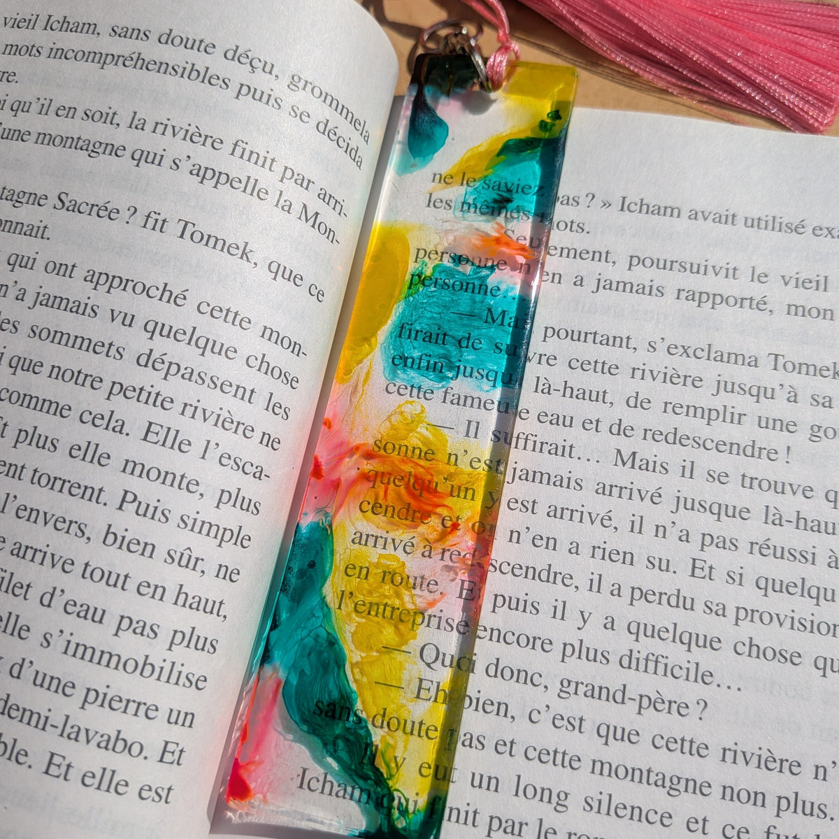 Side angle of yellow teal pink epoxy resin bookmark showing mirror-polish finish on book – EL-Creations