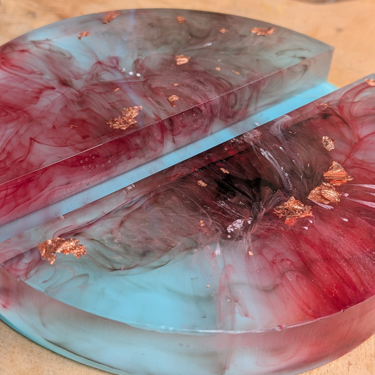 Turquoise and burgundy resin phone stand holding a smartphone - EL-Creations