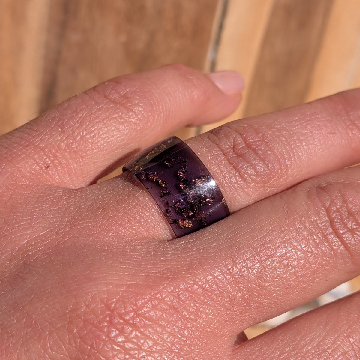 Front view of an 11 mm wide purple resin ring with copper flakes worn in sunlight, EL-Creations
