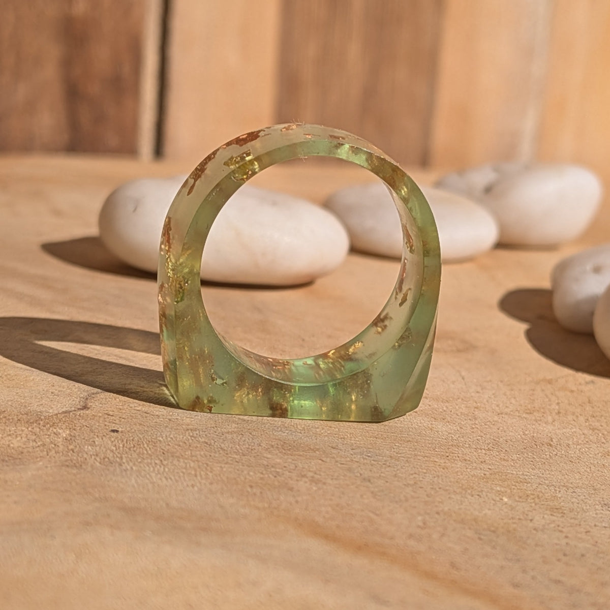 Side profile of a green resin ring standing upright, showing its circular inner opening and angular outer shape, EL-Creations