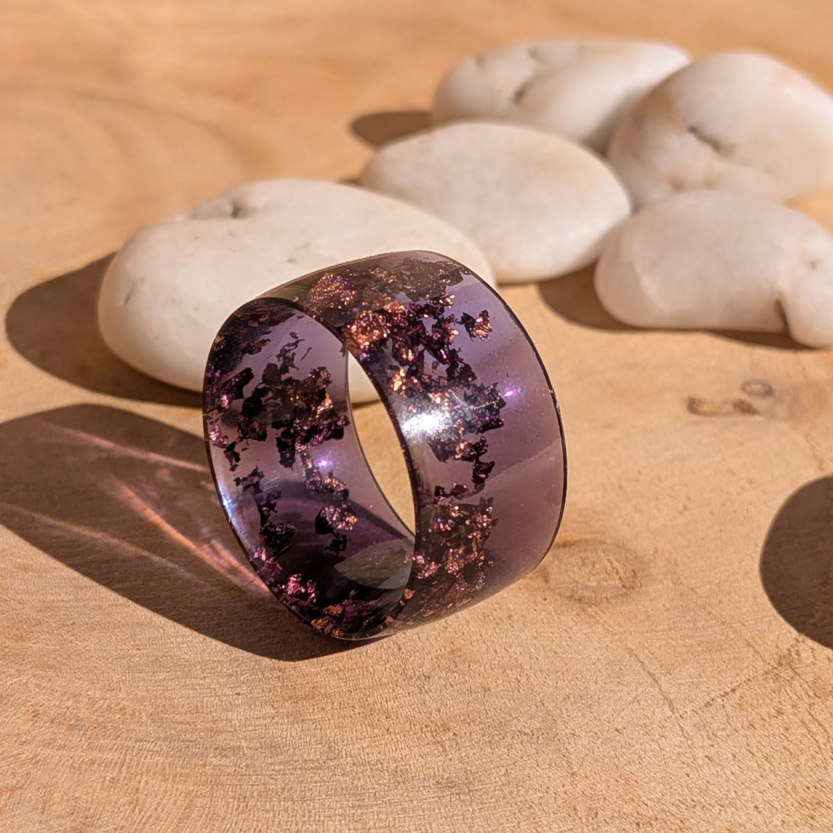 Purple resin ring standing upright, showing its circular opening and embedded copper flakes, EL-Creations