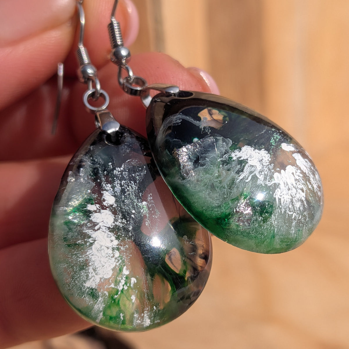 Macro detail of green black resin drops with pale silvery-looking patterns, EL-Creations