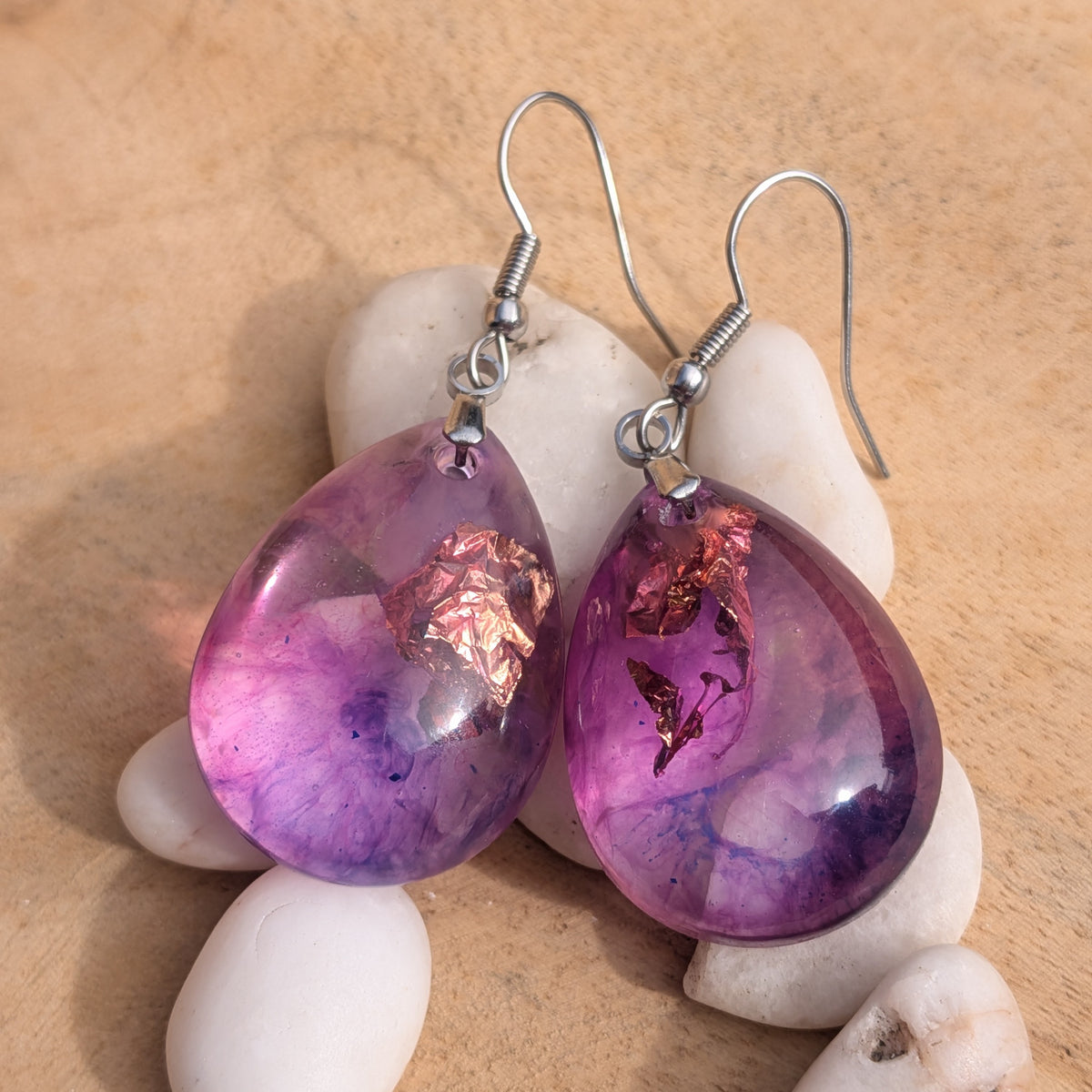 Violet pink teardrop earrings arranged upright among white stones, EL-Creations