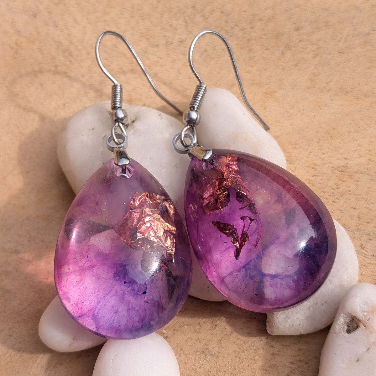 Front view of glossy purple pink resin earrings with copper-coloured details, EL-Creations