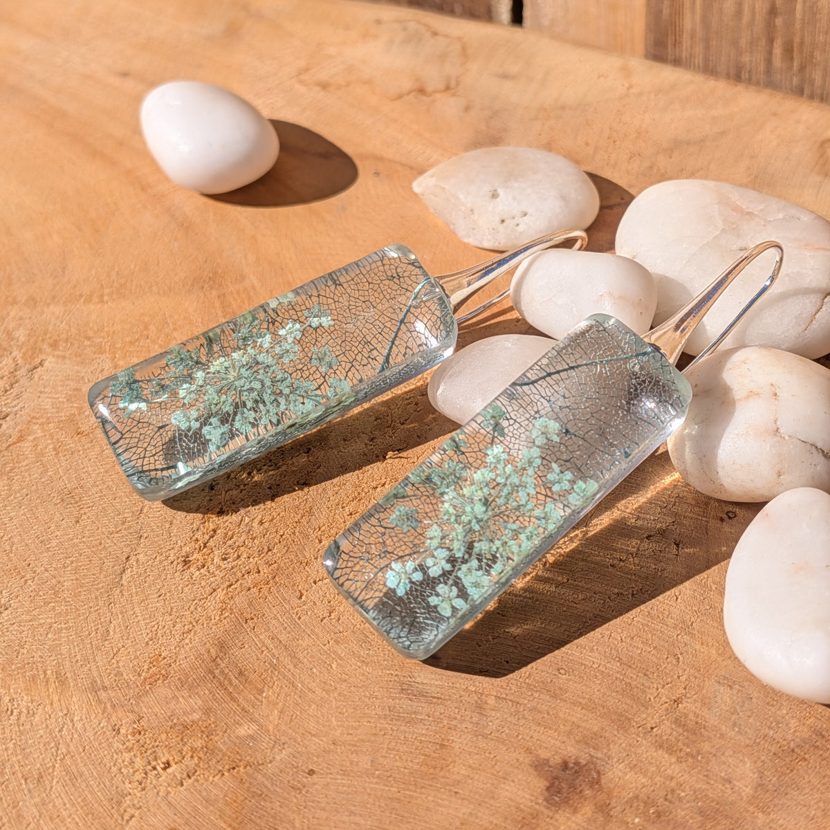 Angled view of Queen Anne's lace and skeleton leaf resin earrings with silver-tone hooks, EL-Creations