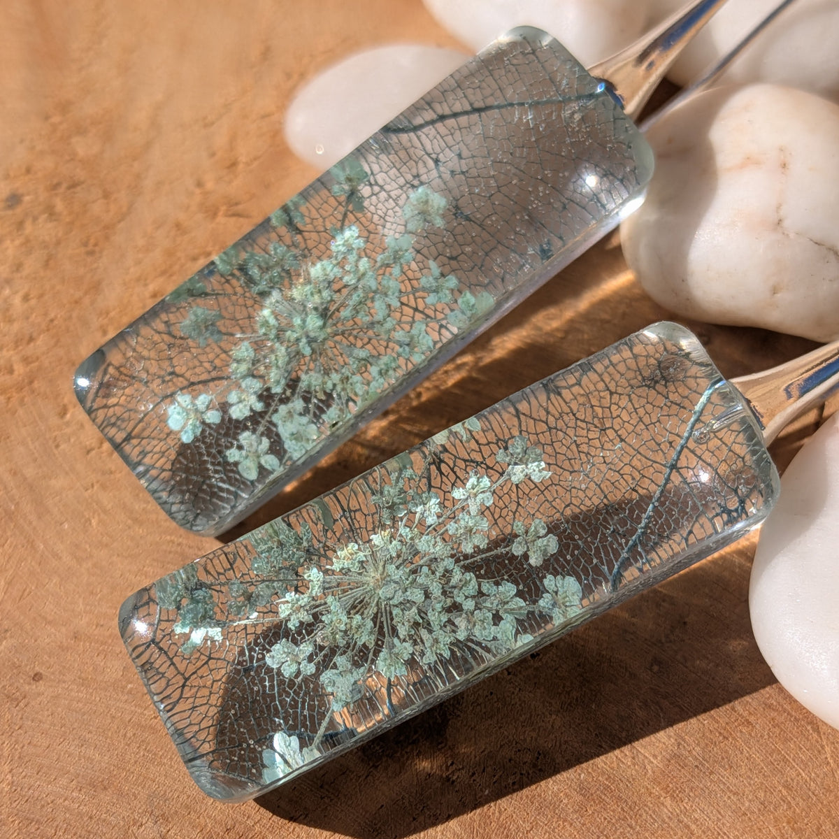 Queen Anne's lace and skeleton leaf earrings with silver-tone alloy hooks resting on wood, EL-Creations