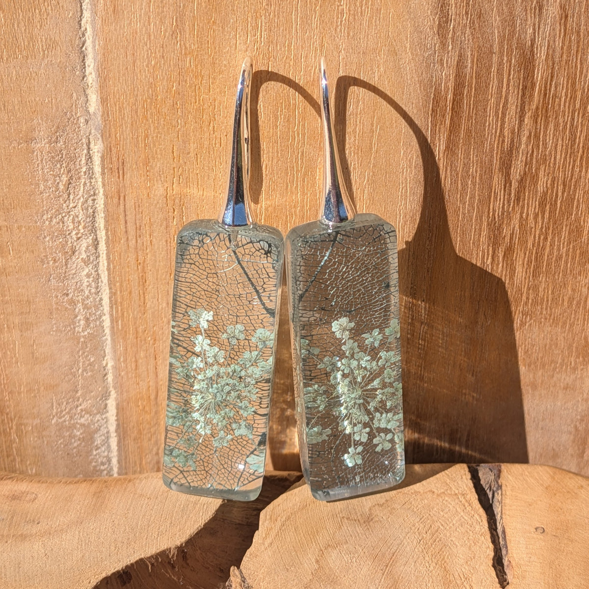 Close-up of delicate Queen Anne's lace flowers and skeleton leaf veins in clear resin earrings, EL-Creations