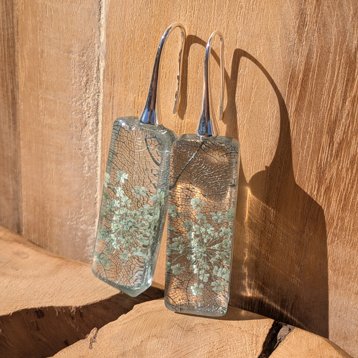 Glossy rectangular botanical earrings with Queen Anne's lace and skeleton leaf in sunlight, EL-Creations
