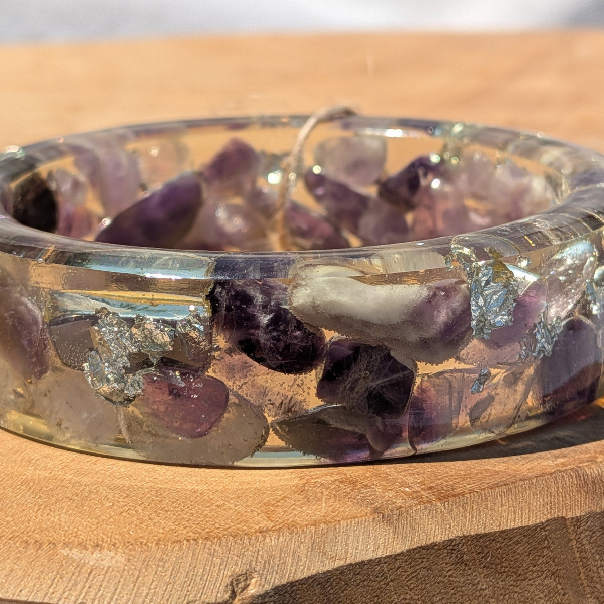 Close-up of real amethyst crystals and silver flakes inside clear resin bangle by EL-Creations