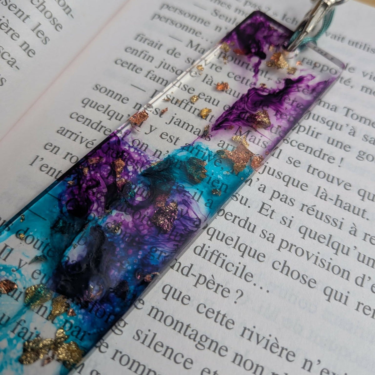 Macro corner detail of black ink swirl with gold leaf in teal purple epoxy resin bookmark – EL-Creations