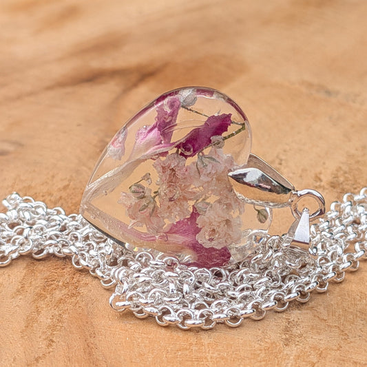 Handmade baby's breath carnation heart necklace resting on natural wood by EL-Creations