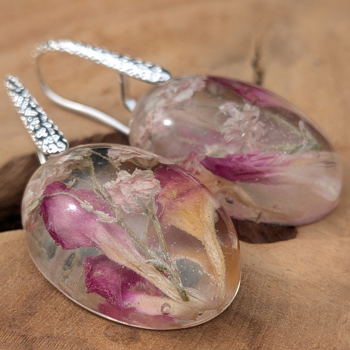 Pair of pink carnation and baby's breath resin oval earrings on natural wood by EL-Creations