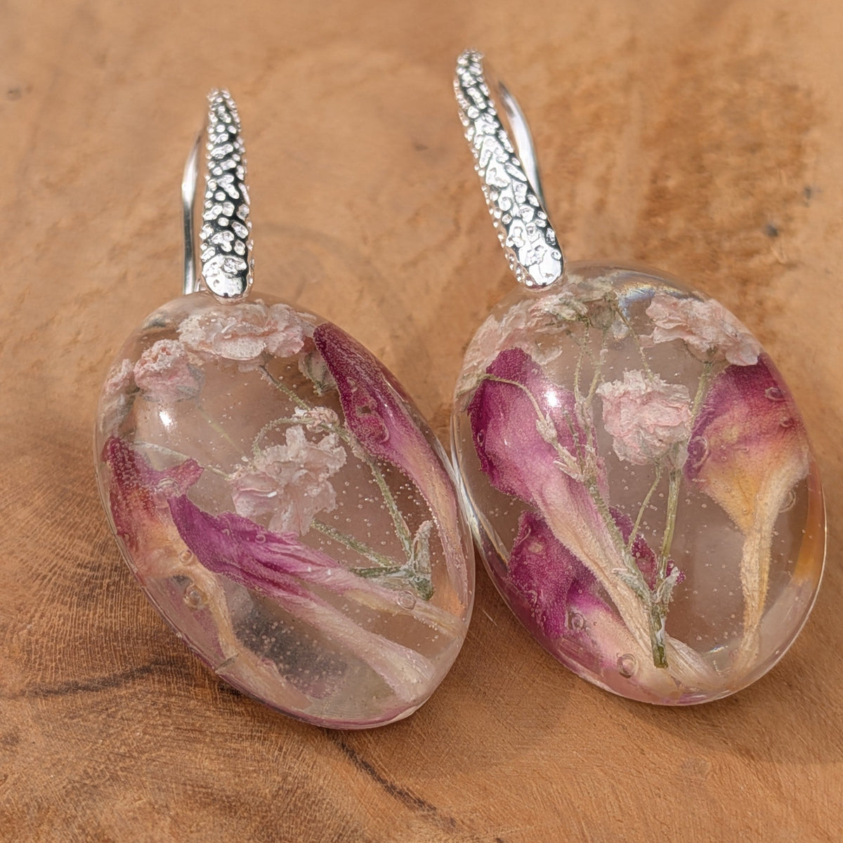 Oval clear resin earrings with baby's breath and magenta carnation petals by EL-Creations