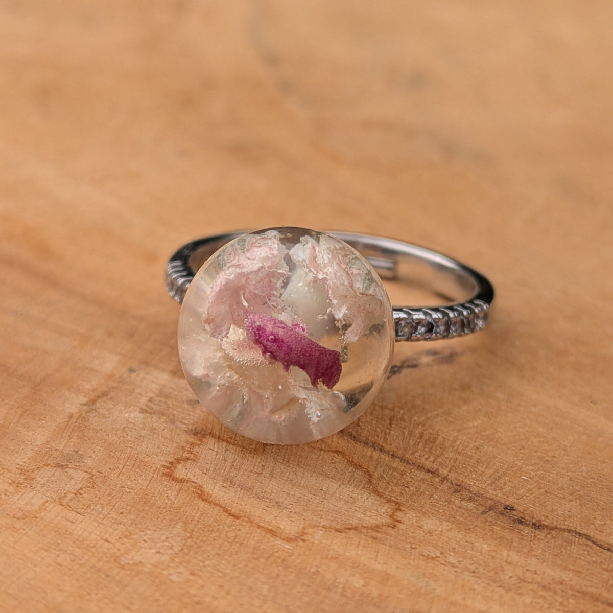 Baby's breath carnation resin sphere ring held against blue sky by EL-Creations