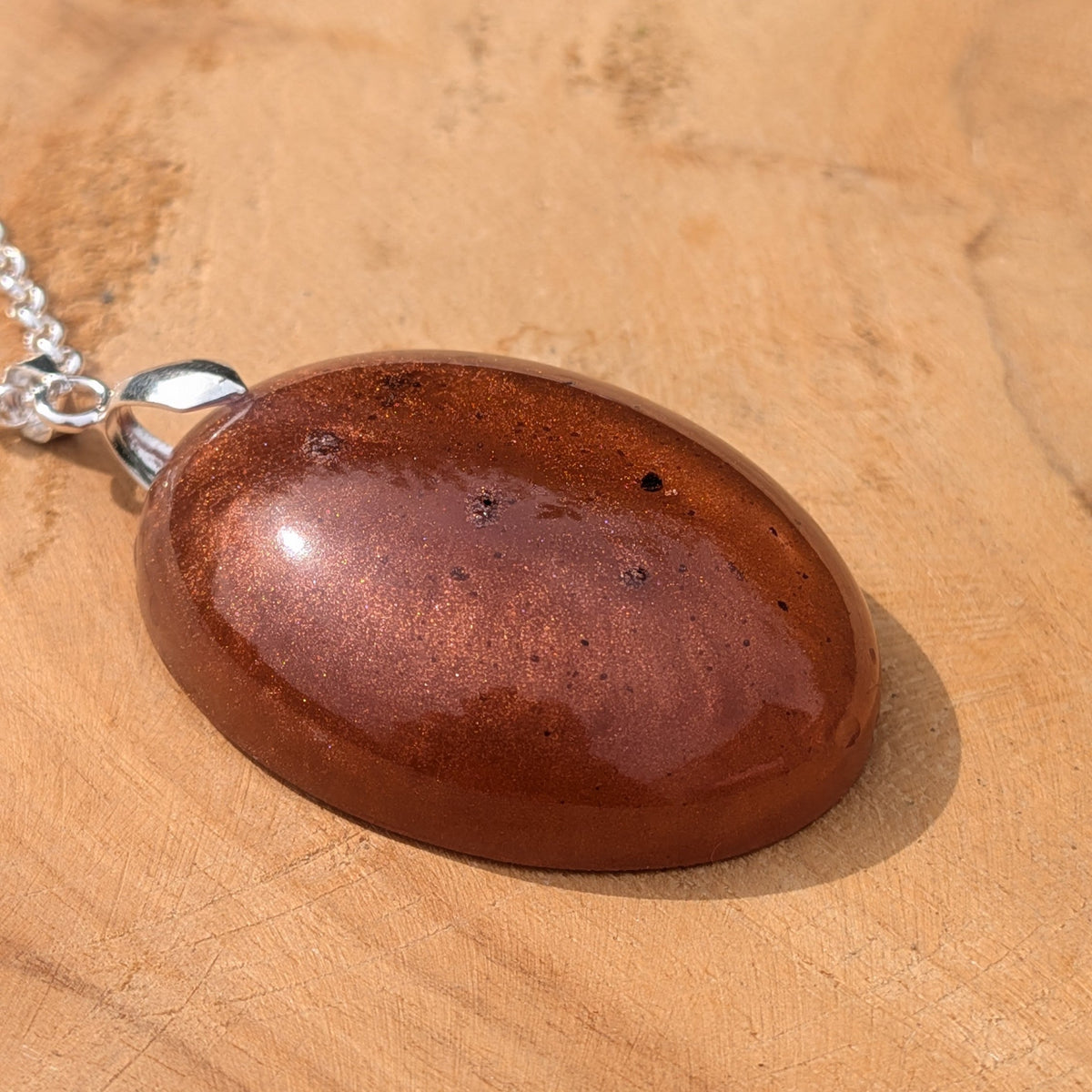 Side view of domed copper shimmer resin pendant on silver chain by EL-Creations