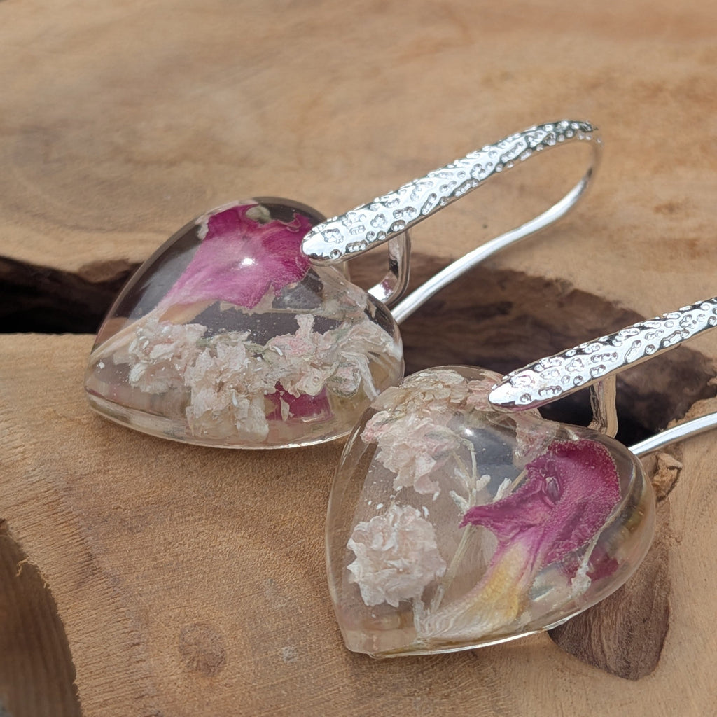 Close-up of baby's breath and carnation petal inside heart resin earrings by EL-Creations