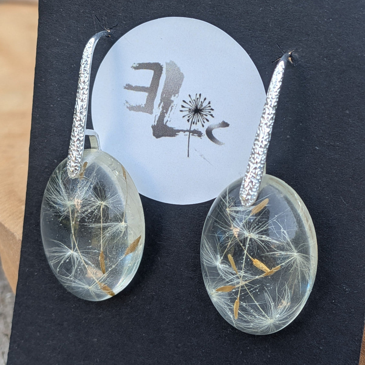Macro of preserved dandelion seed parachutes inside clear resin drop earrings by EL-Creations
