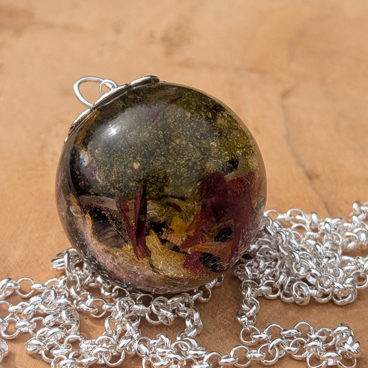 Clear resin orb pendant filled with green moss and burgundy tulip petals by EL-Creations
