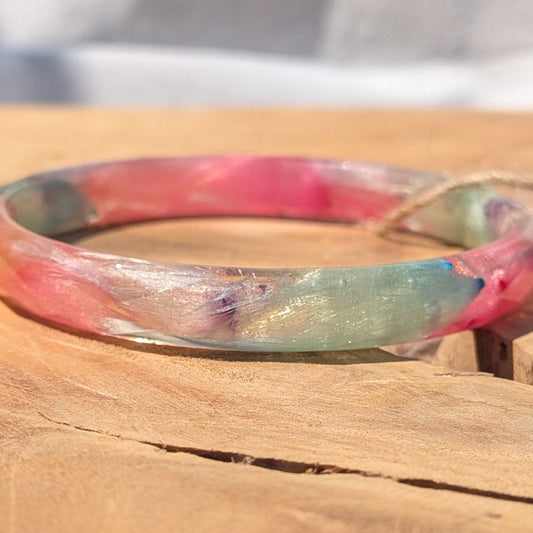 Pastel pink and blue feather resin bangle bracelet on natural wood by EL-Creations