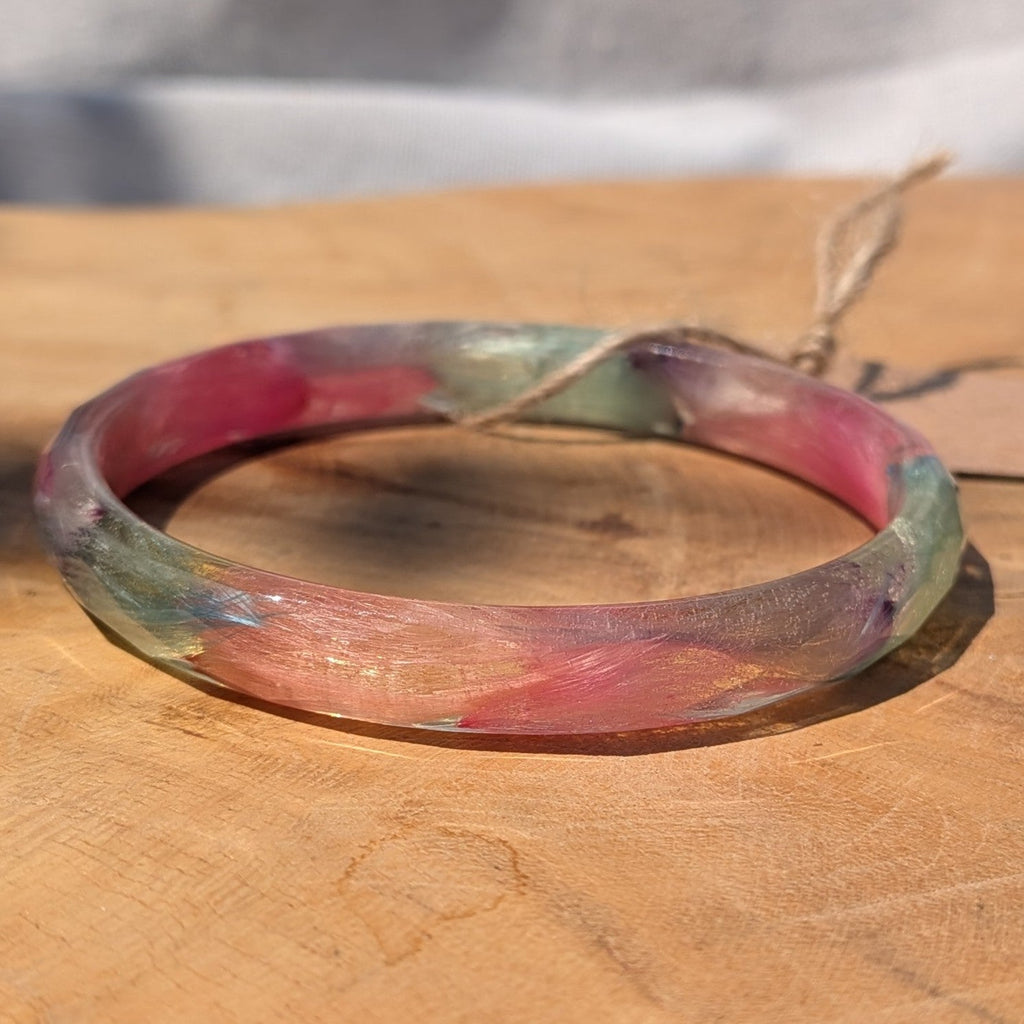 Clear resin cuff bracelet with real pink and blue feathers in sunlight by EL-Creations
