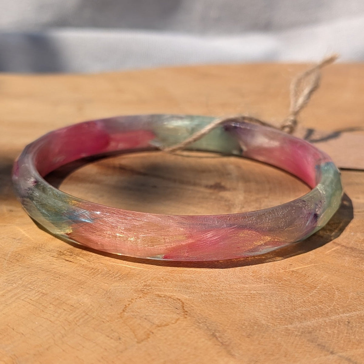 Clear resin cuff bracelet with real pink and blue feathers in sunlight by EL-Creations