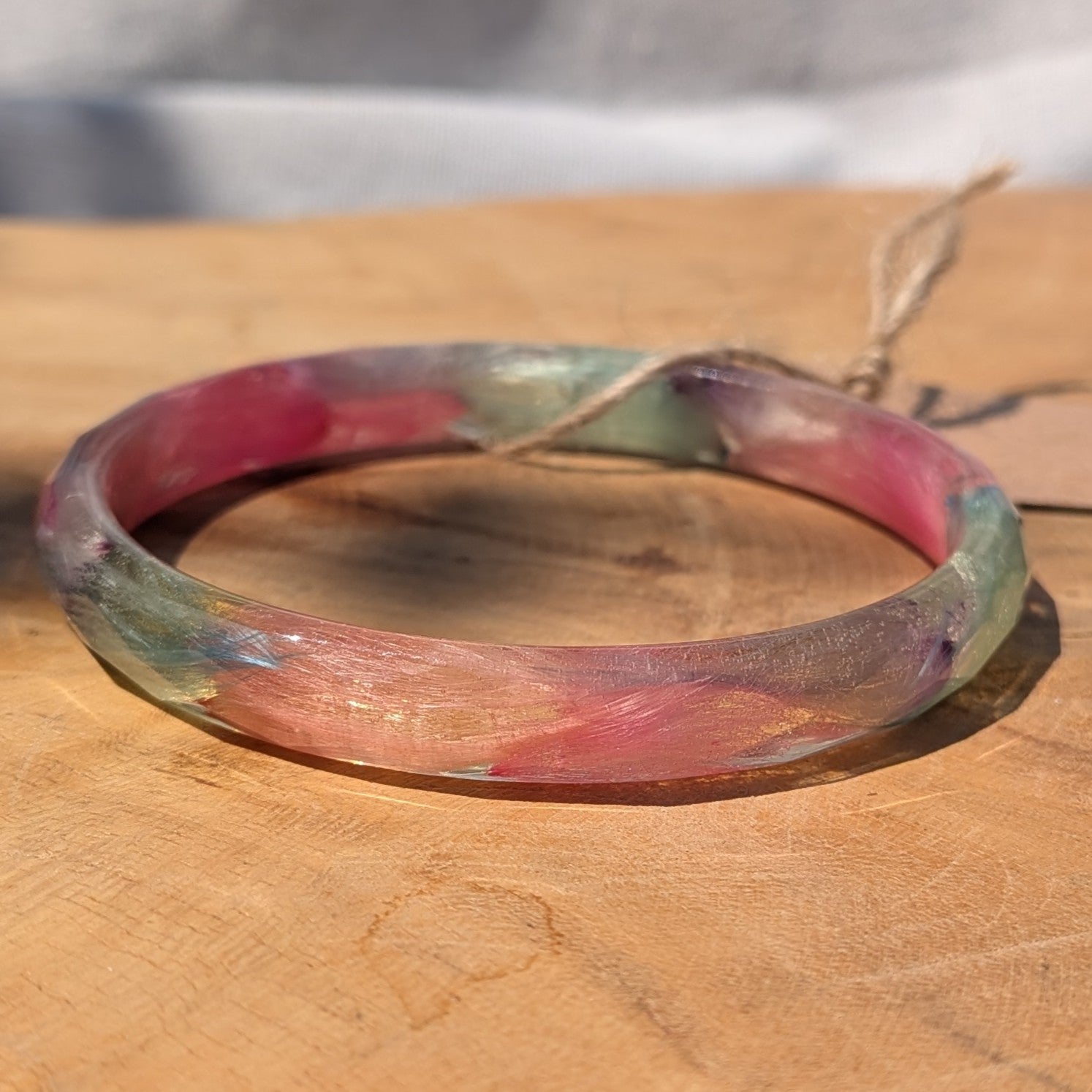 Clear resin cuff bracelet with real pink and blue feathers in sunlight by EL-Creations