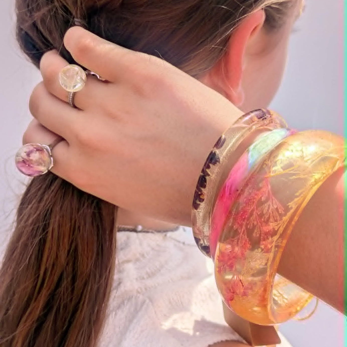 Pastel feather resin cuff bracelet worn on wrist in sunlight by EL-Creations