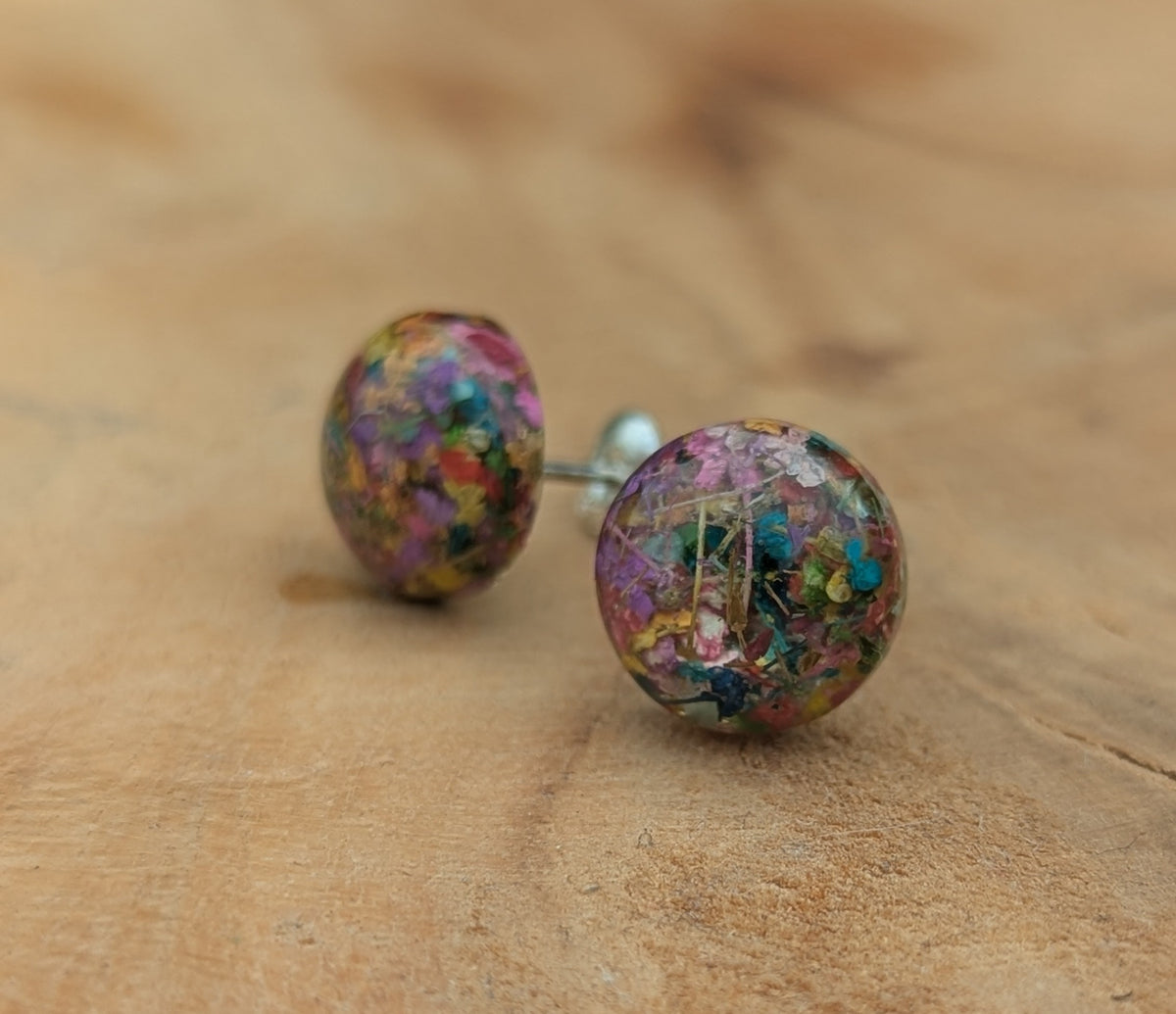 Handmade rainbow flower resin stud earrings worn on ear, colorful botanical jewelry EL Creations Belgium