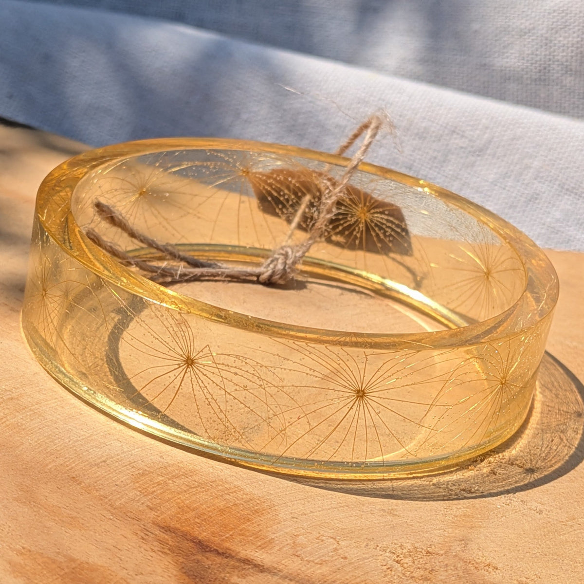 Top view of golden resin bangle with feathery wild seeds by EL-Creations