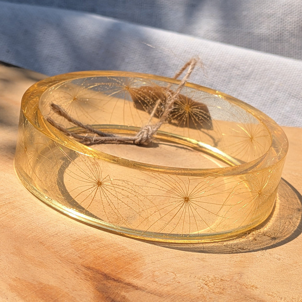 Wild wishflower seed resin bangle resting on wooden surface by EL-Creations