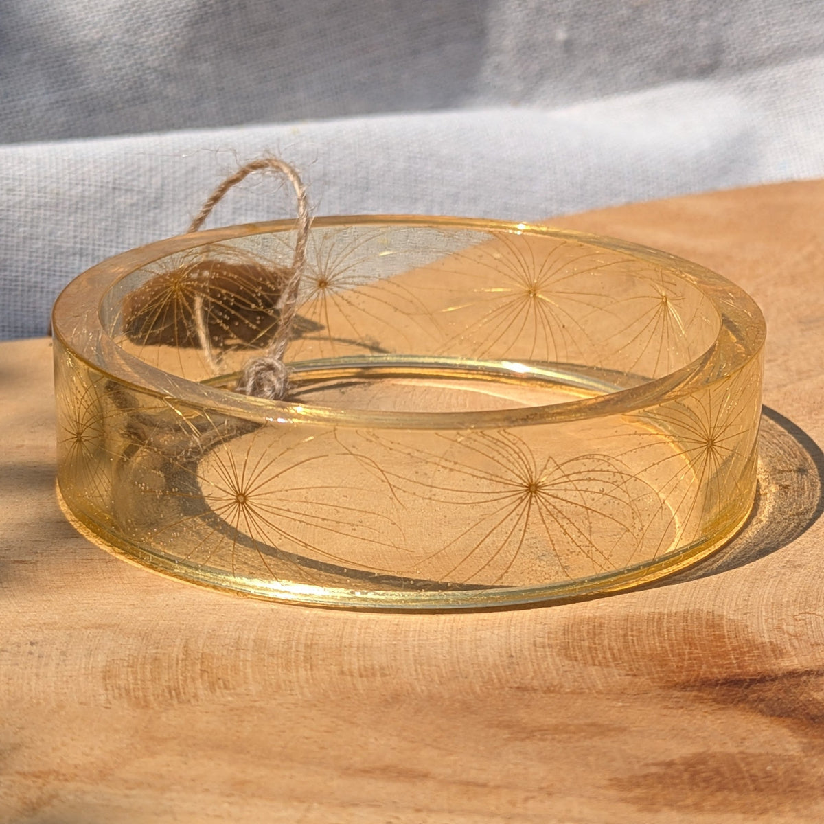Golden clear resin bangle bracelet with real wild wishflower seeds in sunlight by EL-Creations