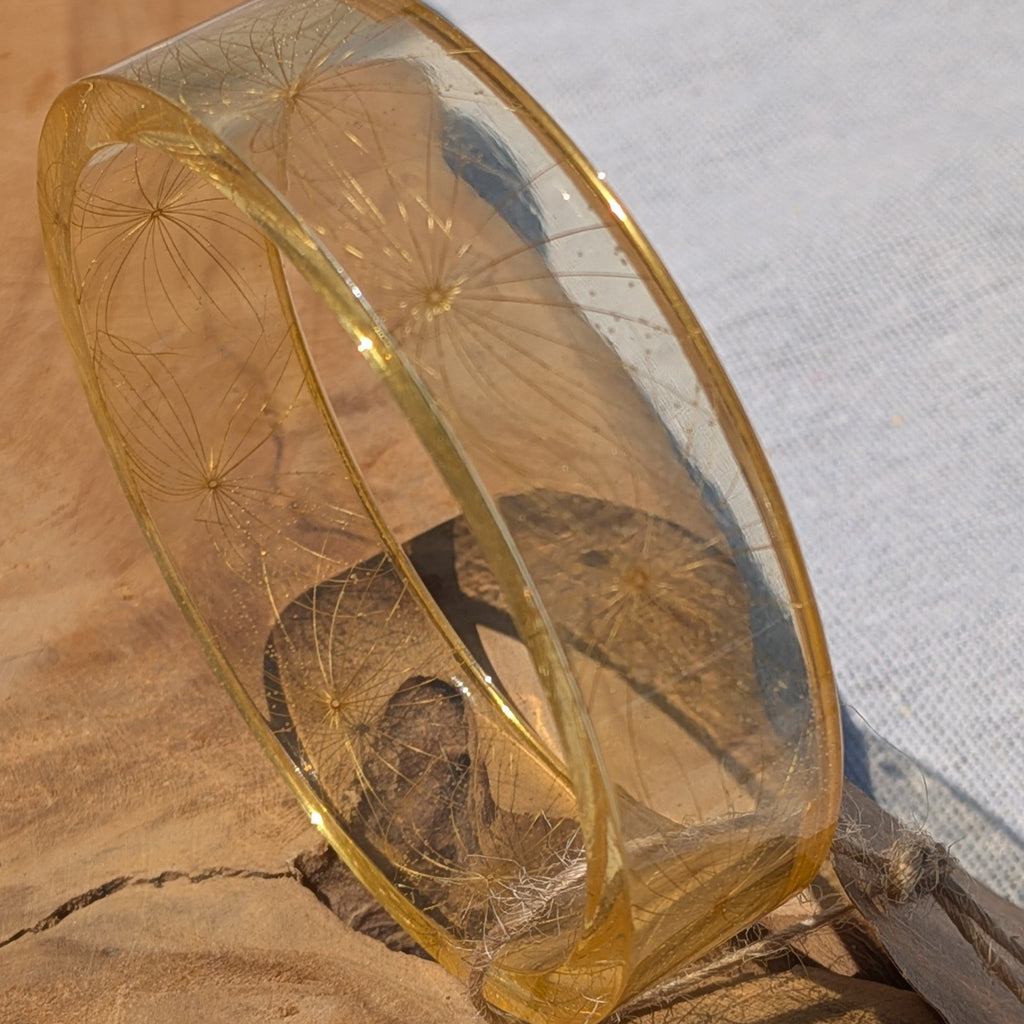 Nature inspired make a wish wildflower seed resin bangle held to light by EL-Creations