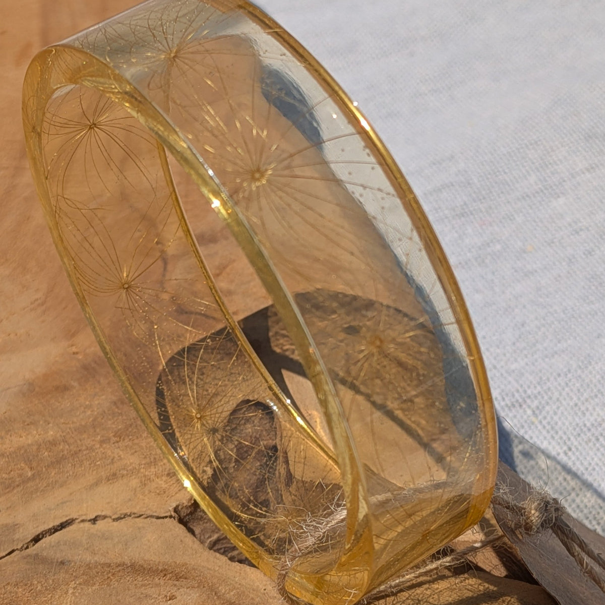 Nature inspired make a wish wildflower seed resin bangle held to light by EL-Creations