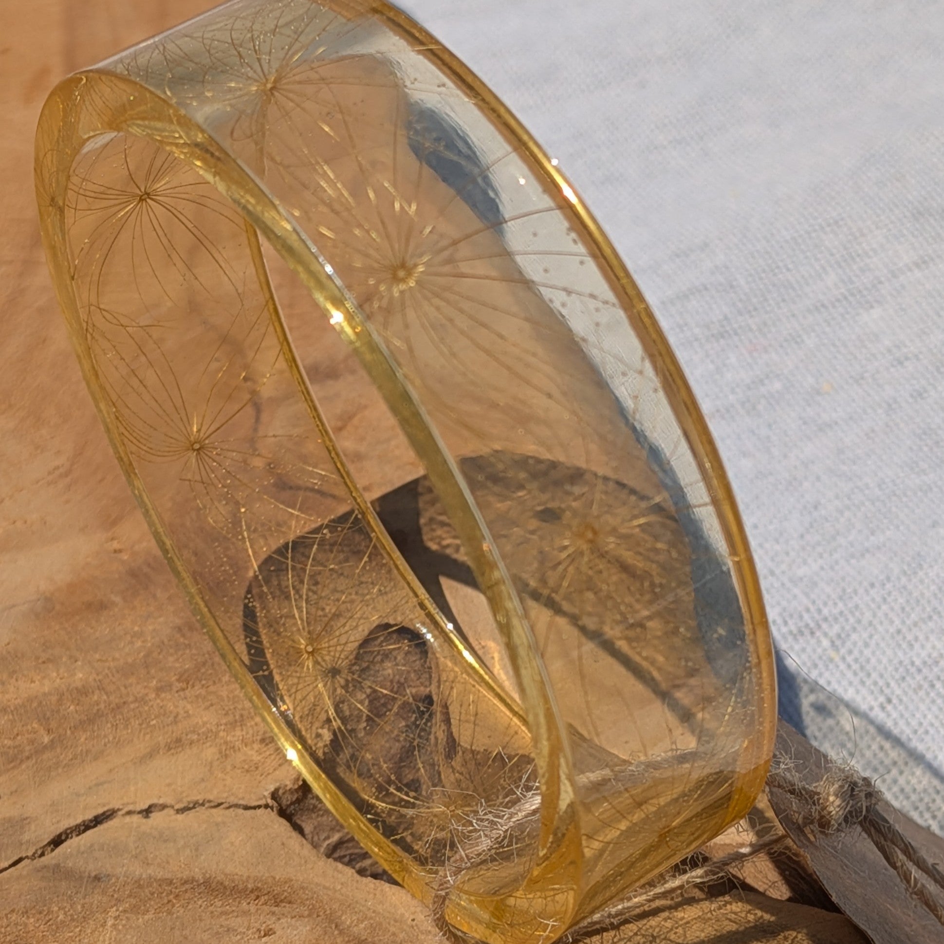 Nature inspired make a wish wildflower seed resin bangle held to light by EL-Creations